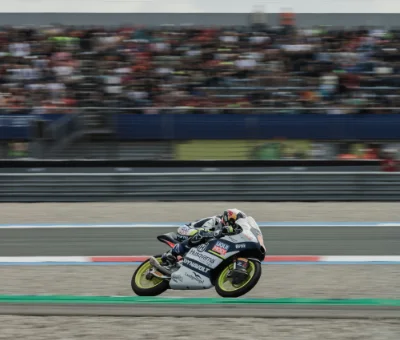 Piloto de MotoGP en pista de carreras con fondo borroso.