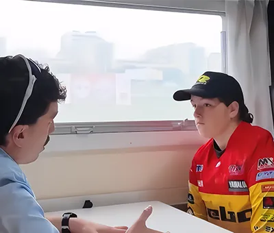 Fisioterapeuta masajea el brazo de un motociclista antes de la carrera
