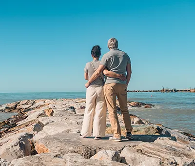 Pareja abrazándose y disfrutando de una relajante vista al mar