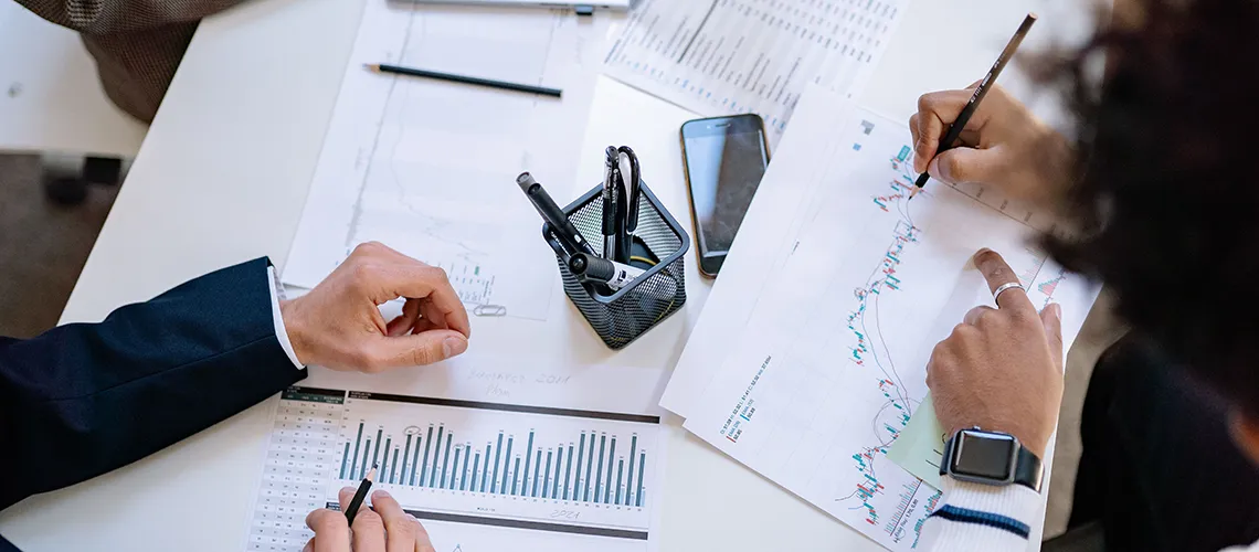 Personas trabajando en un escritorio con gráficos logísticos